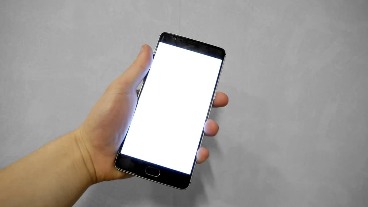 Hand holding a smartphone with a blank white screen, evoking choosing a streaming or player app